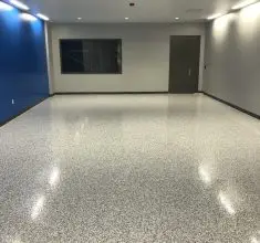 Modern commercial interior with seamless gray epoxy flooring, showcasing a high-gloss, durable, slip-resistant surface designed for offices, commercial buildings, and high-traffic professional spaces.