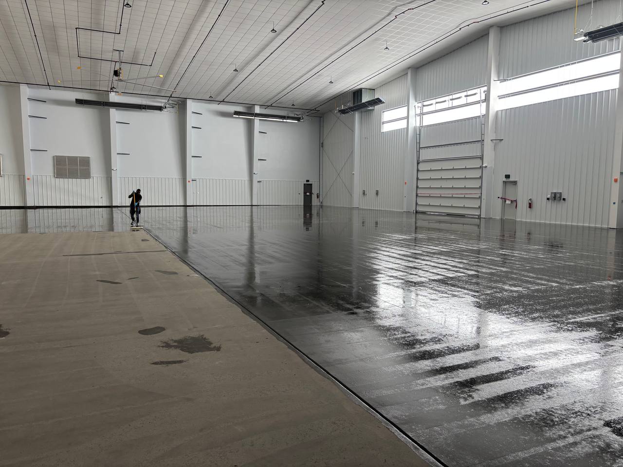 Industrial hangar floor coating in progress at Perkins Hangar, Wright-Patterson Air Force Base